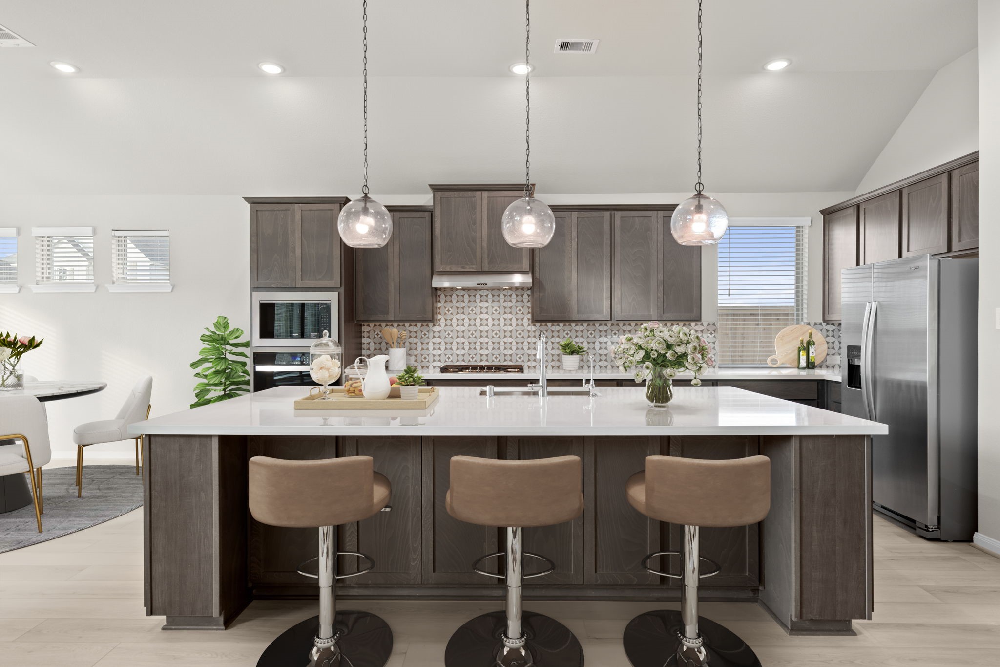 6402 Citron Elm Road Manvel, TX 77578 - Photo 2 of 37 a kitchen with a refrigerator a sink and chairs