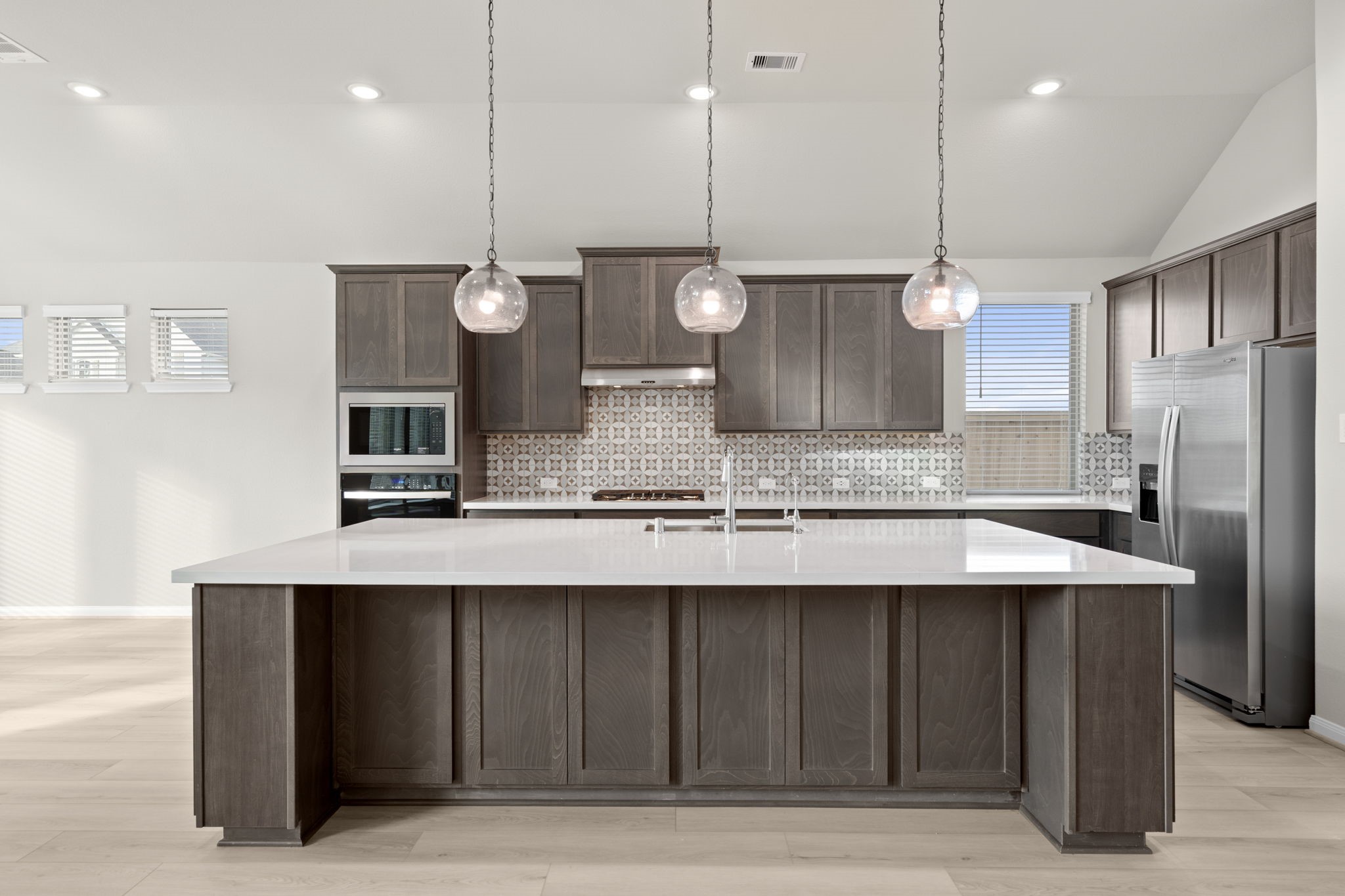 6402 Citron Elm Road Manvel, TX 77578 - Photo 3 of 37 a kitchen with a refrigerator a sink and wooden floor