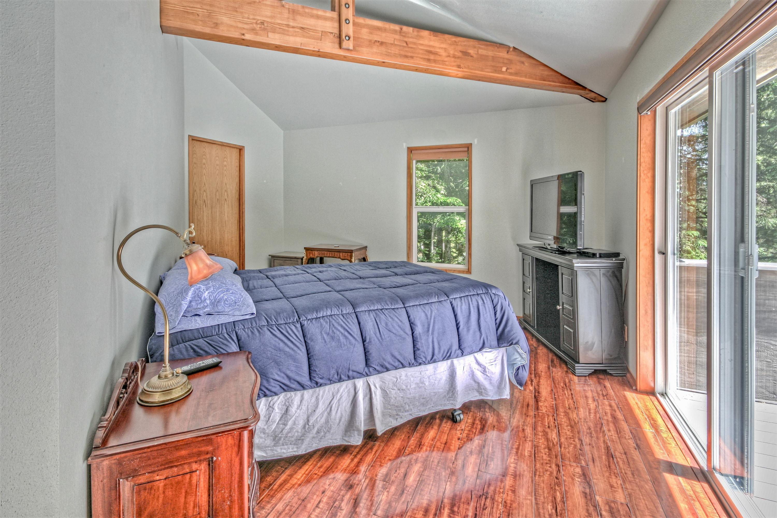 17 Big Tree Road Gleneden Beach, OR 97388 - Photo 21 of 52 a bed sitting in a bedroom next to a window