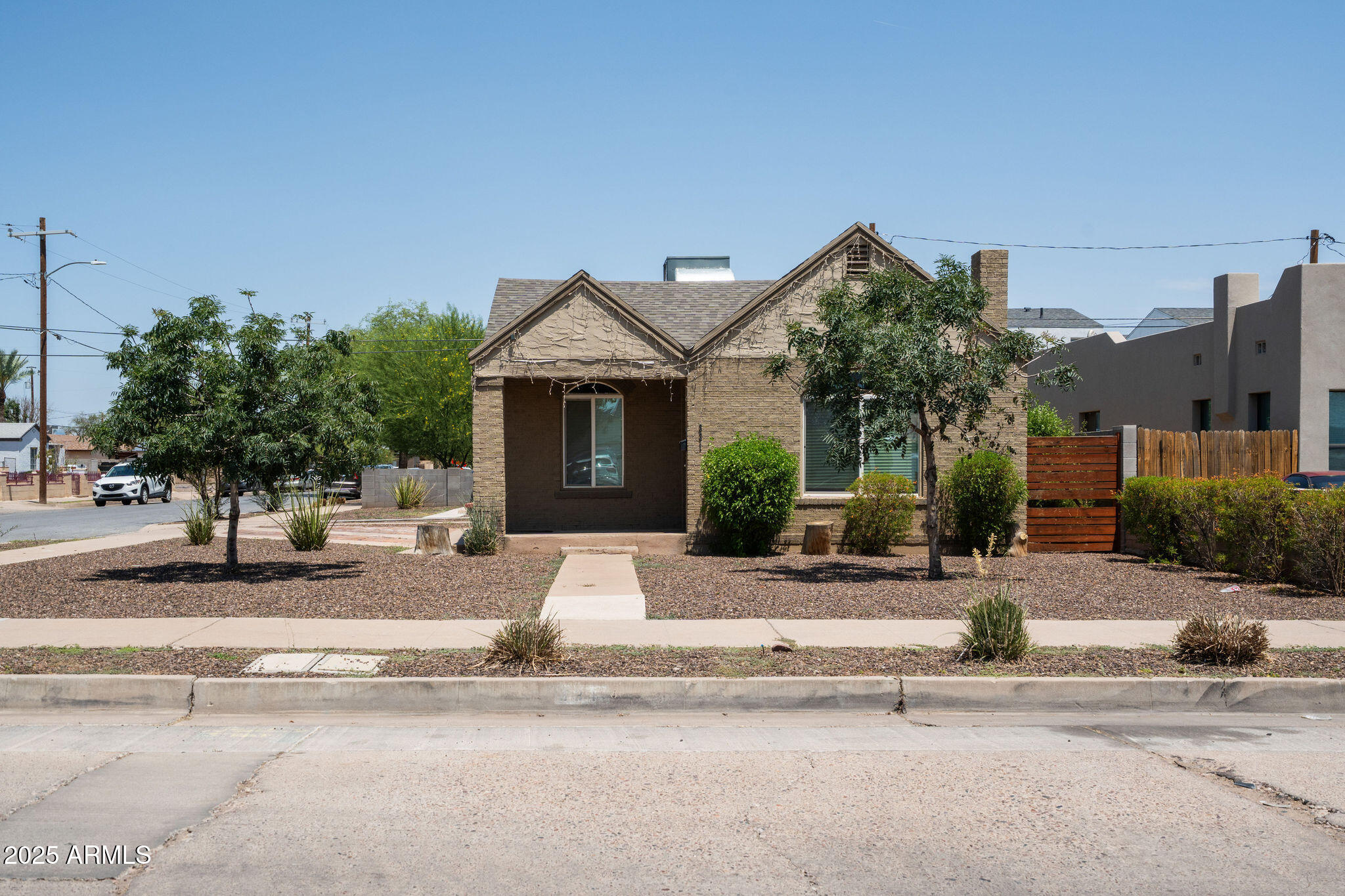 a front view of a house with a yard and palm trees