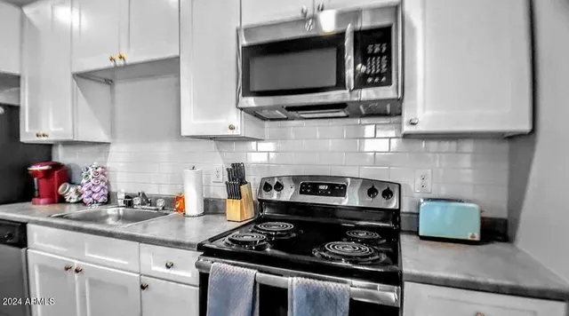 a kitchen with stainless steel appliances a stove and a microwave