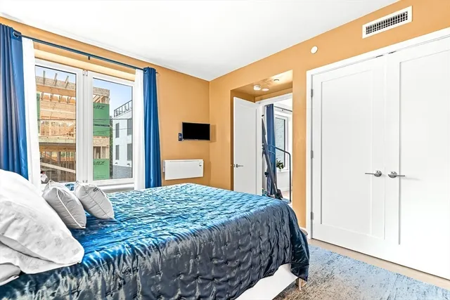 a bedroom with a bed and a large window with outer view