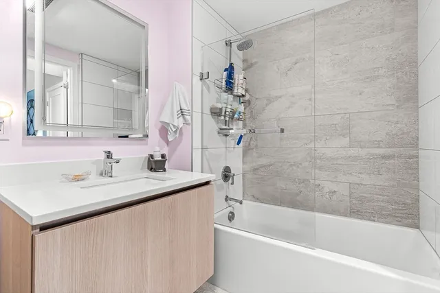a bathroom with a granite countertop sink mirror toilet and bathtub