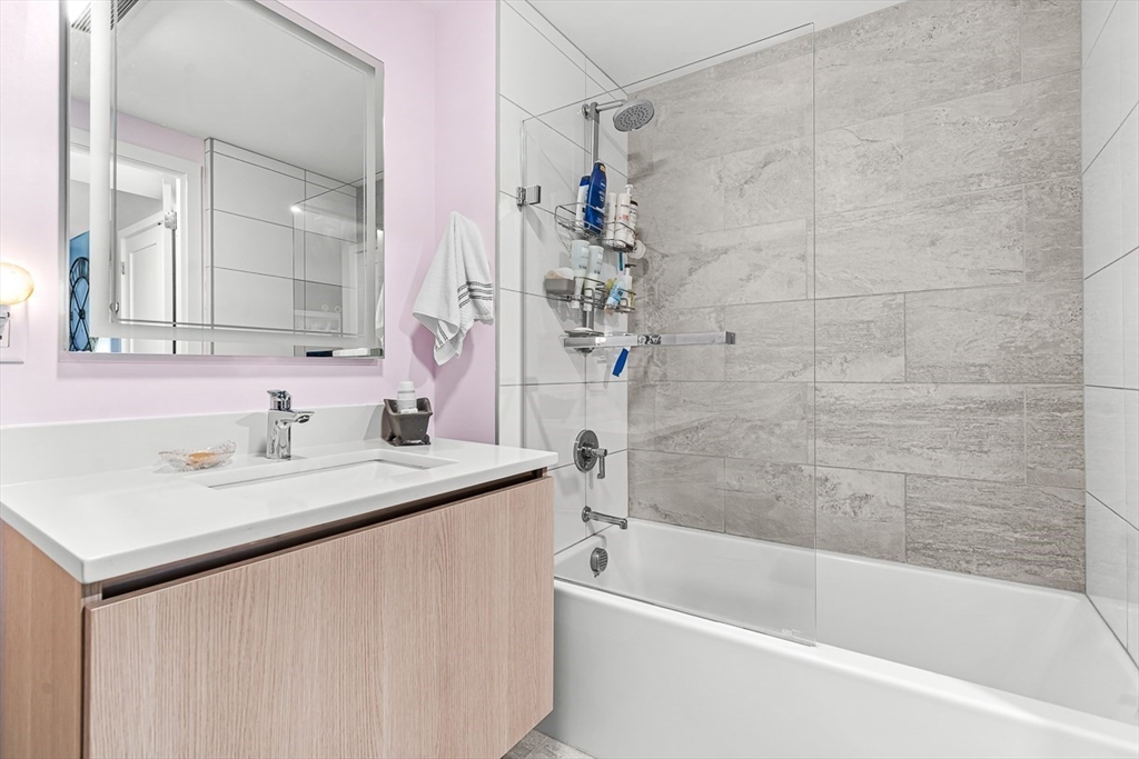 932 Broadway, Unit 208 Chelsea, MA 02150 - Photo 15 of 25 a bathroom with a granite countertop sink mirror toilet and bathtub