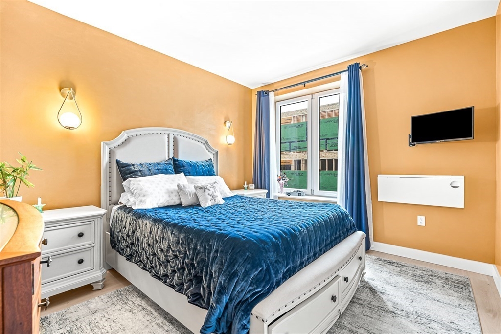 932 Broadway, Unit 208 Chelsea, MA 02150 - Photo 19 of 25 a bedroom with a bed and a window