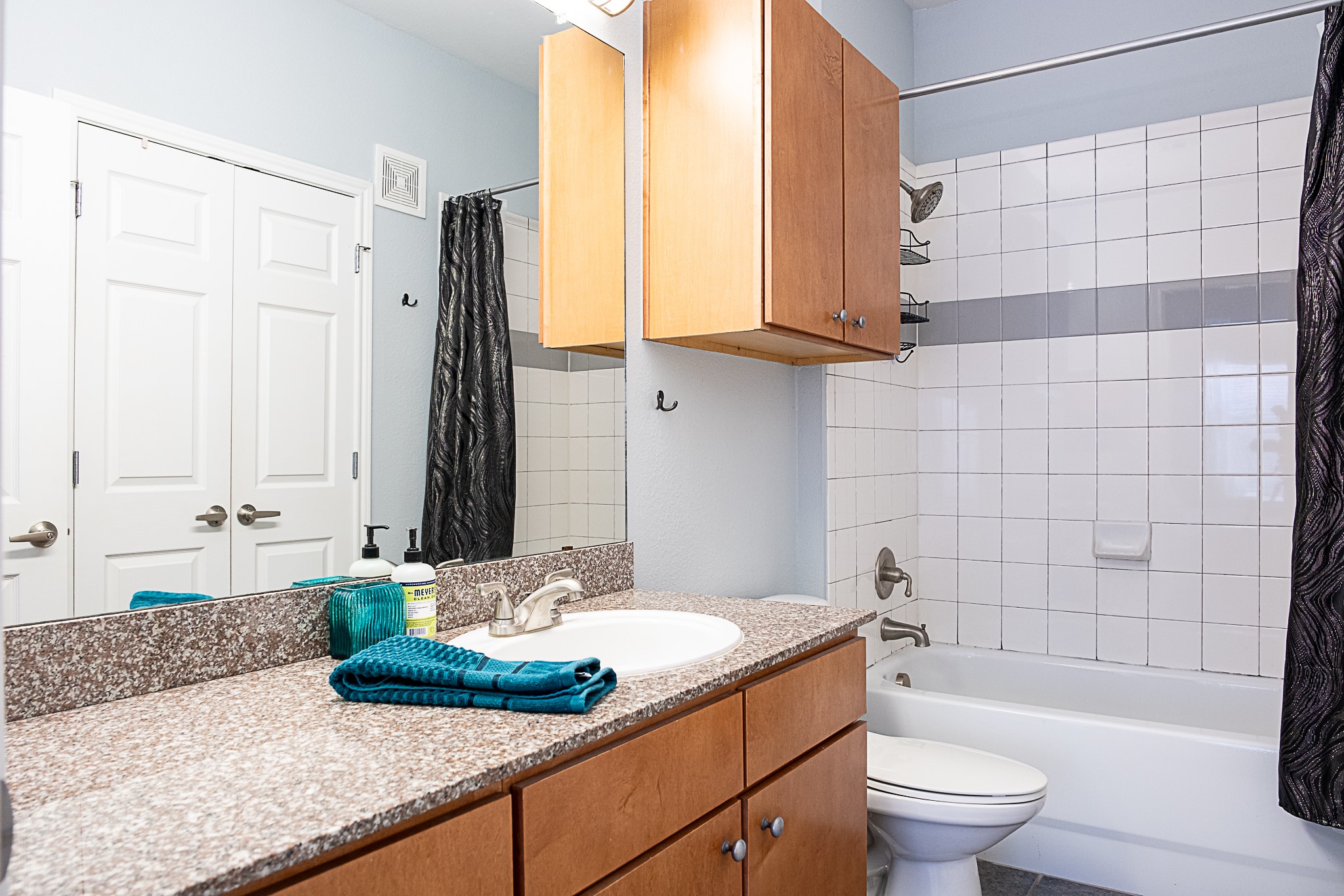 2502 Leon Street, Unit 309 Austin, TX 78705 - Photo 13 of 19 a bathroom with a granite countertop bathtub sink vanity mirror and toilet