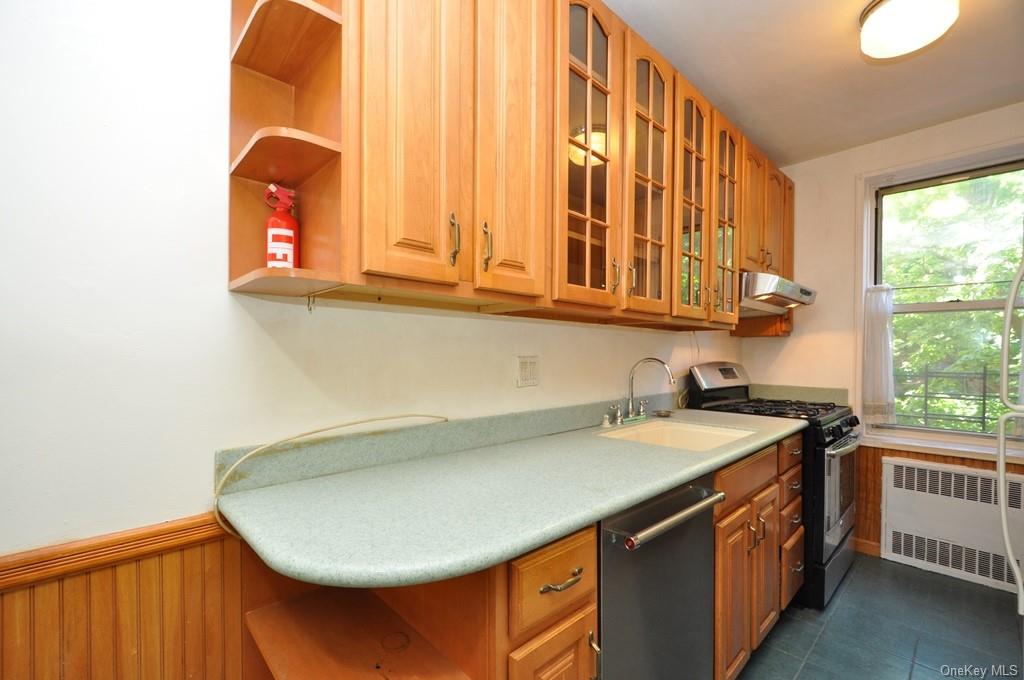 Renovated Eat-in-Kitchen has Corian counters and stainless steel appliances.