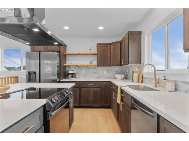 a kitchen with a sink a stove a refrigerator and cabinets