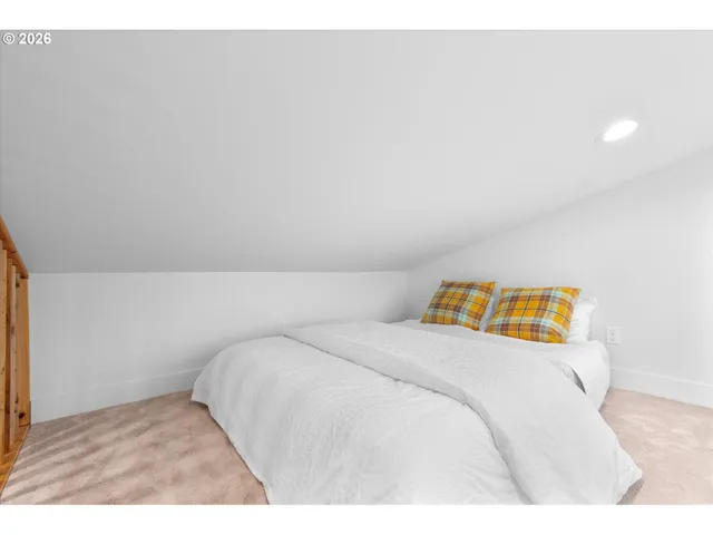 a bedroom with a bed and a painting on the wall