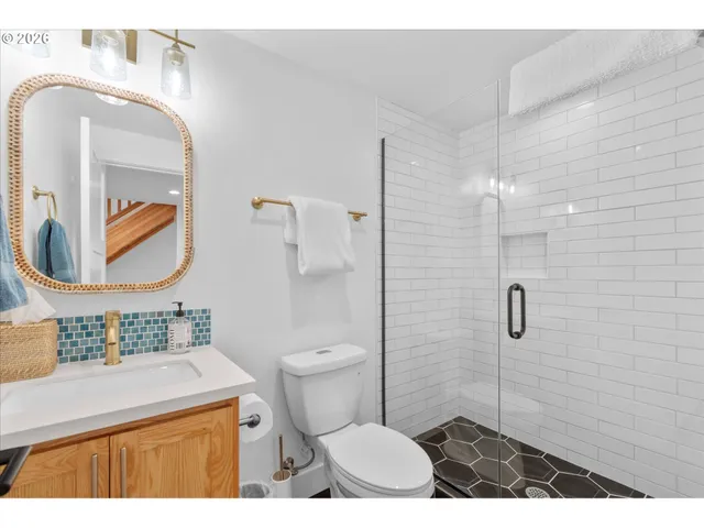 a bathroom with a sink a toilet and shower