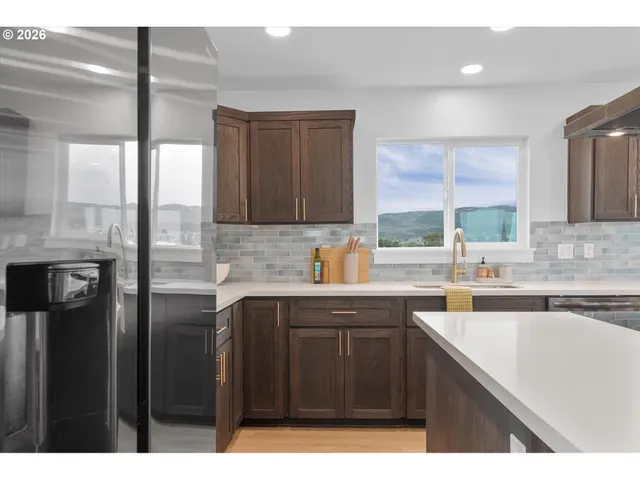 a kitchen with stainless steel appliances granite countertop a sink a stove and a refrigerator