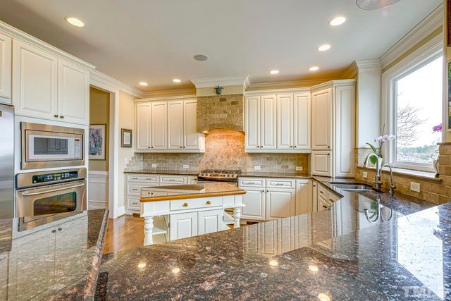 a kitchen with stainless steel appliances granite countertop a stove sink and cabinets