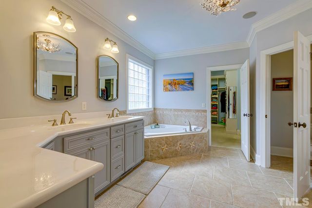 a spacious bathroom with a tub sink and mirror