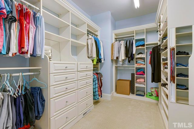 a view of walk in closet with clothes
