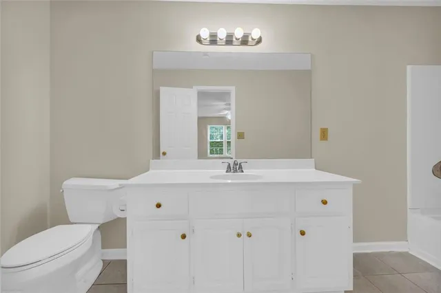 an empty room with windows and chandelier fan