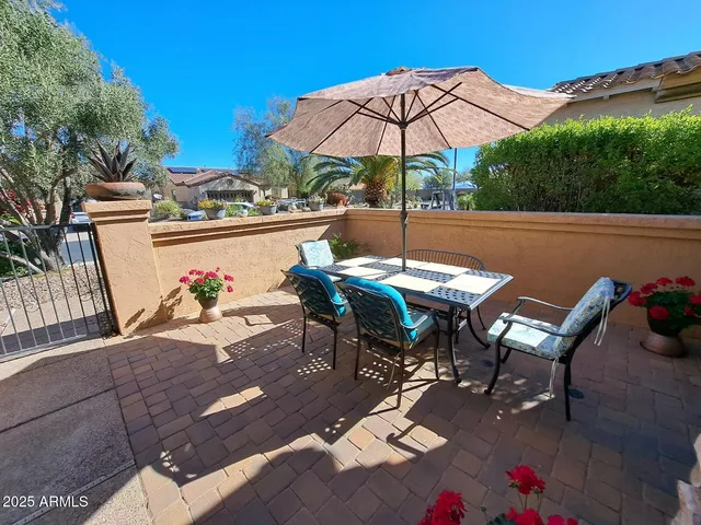 a view of a patio with table and chairs under an umbrella