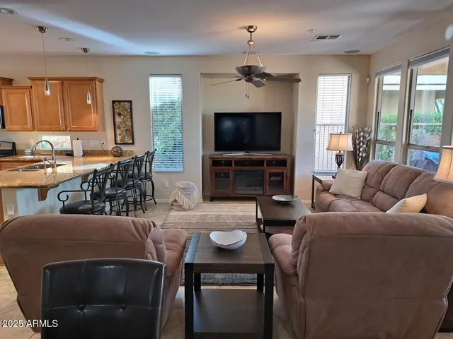 a living room with furniture a flat screen tv and large window