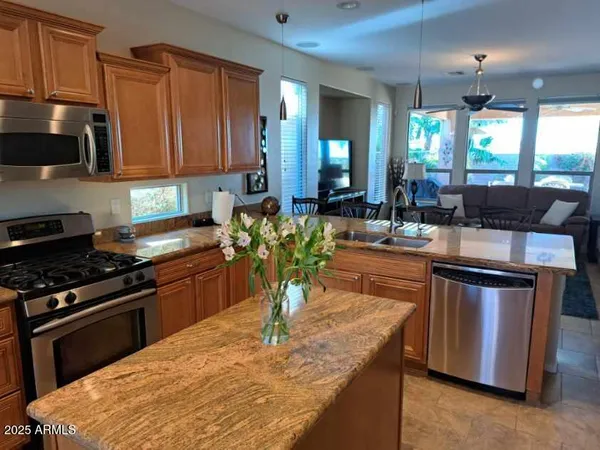 a kitchen with stainless steel appliances granite countertop a stove a sink and a microwave