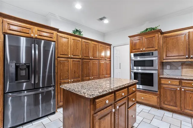 a kitchen with stainless steel appliances granite countertop a refrigerator and stove