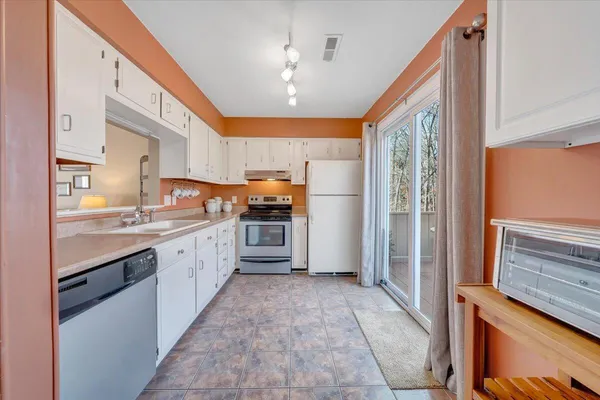 a large kitchen with stainless steel appliances kitchen island granite countertop a refrigerator and a stove