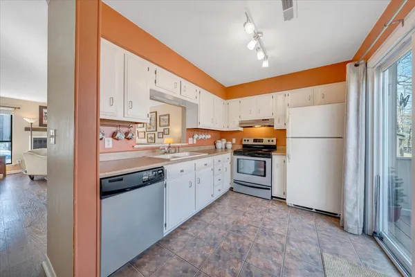a kitchen with stainless steel appliances granite countertop a refrigerator and a stove top oven