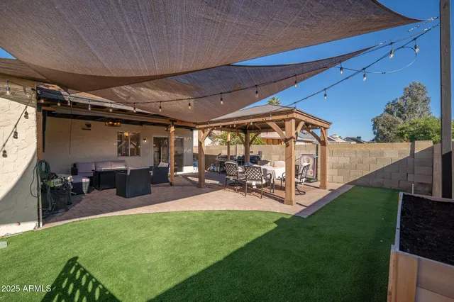 a view of a backyard with table and chairs and potted plants