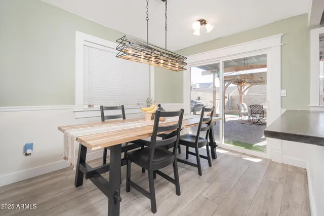 a view of a dining room and livingroom with furniture wooden floor a chandelier