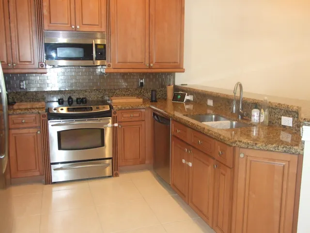 a kitchen with stainless steel appliances granite countertop a stove a sink and a microwave