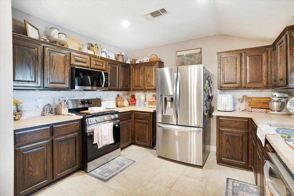90 Williams Trail Howe, TX 75459 - Photo 3 of 18 a kitchen with stainless steel appliances granite countertop a refrigerator stove a sink and a microwave