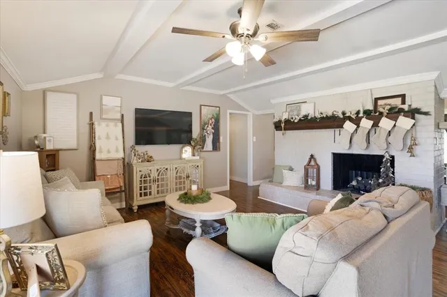 a living room with furniture a fireplace and a flat screen tv