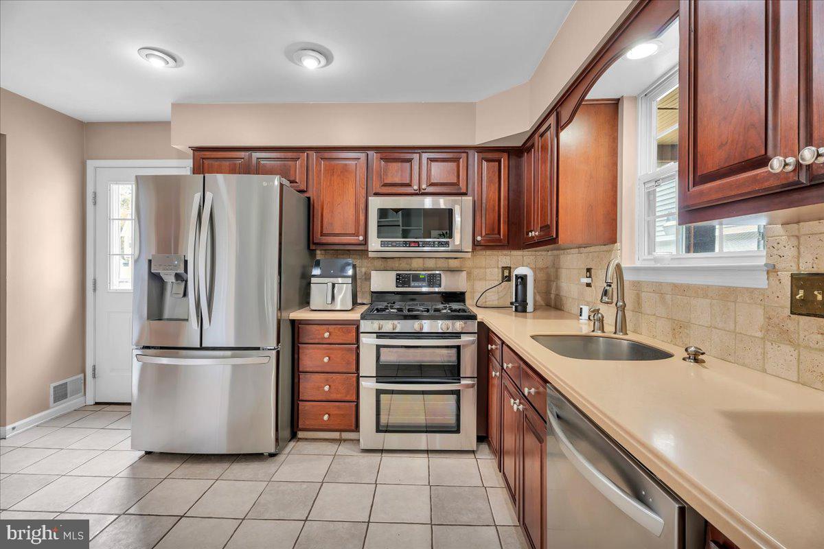 48 Country Club Road Pine Hill, NJ 08021 - Photo 18 of 40 a kitchen with stainless steel appliances granite countertop a refrigerator a stove a sink and a microwave