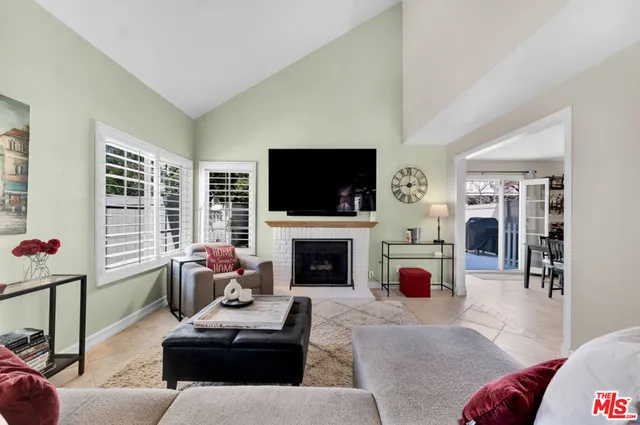 a living room with furniture a flat screen tv and a fireplace