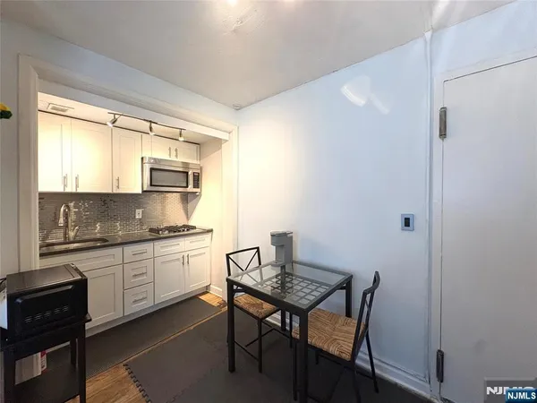 a kitchen with stainless steel appliances granite countertop a stove a sink a refrigerator and a granite counter tops with white cabinets