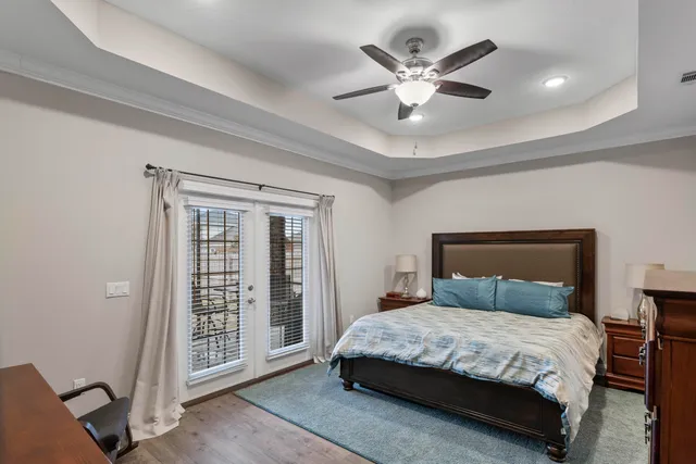 a bedroom with a large bed and a ceiling fan