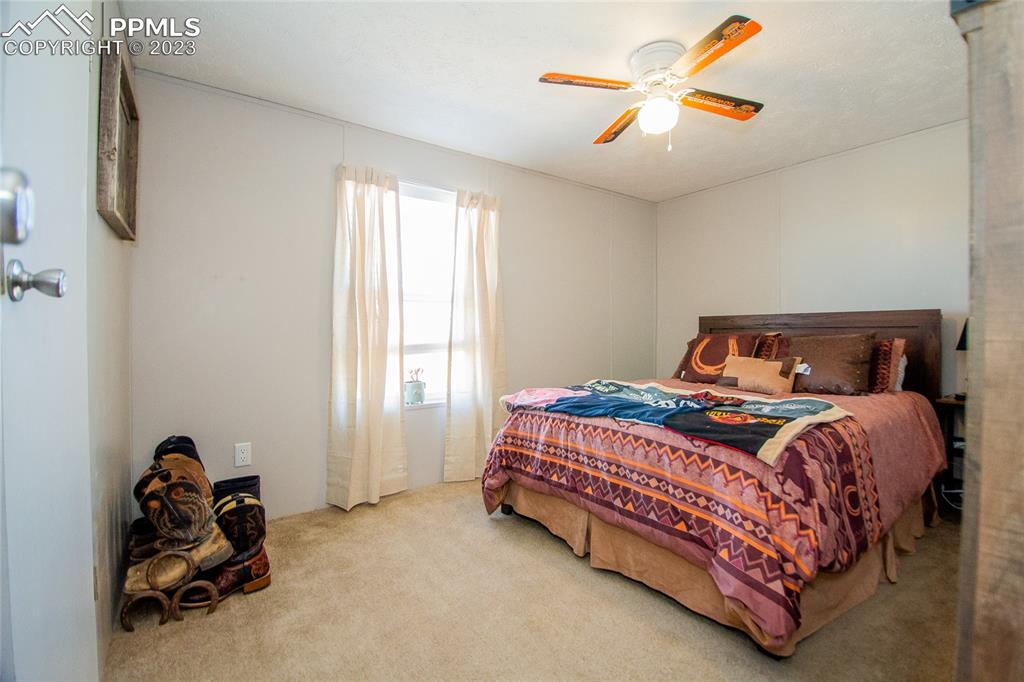 1880 Johnson Road North Rush, CO 80833 - Photo 12 of 40 a bedroom with a bed and a chandelier