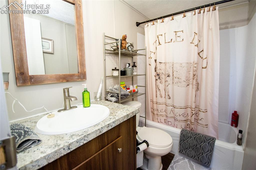 1880 Johnson Road North Rush, CO 80833 - Photo 15 of 40 a bathroom with a granite countertop sink and a mirror