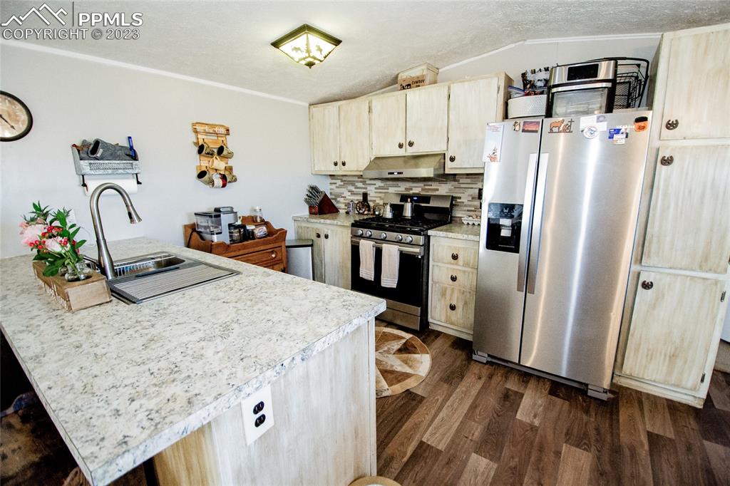 1880 Johnson Road North Rush, CO 80833 - Photo 8 of 40 a kitchen with granite countertop a refrigerator a stove a sink dishwasher and wooden floor