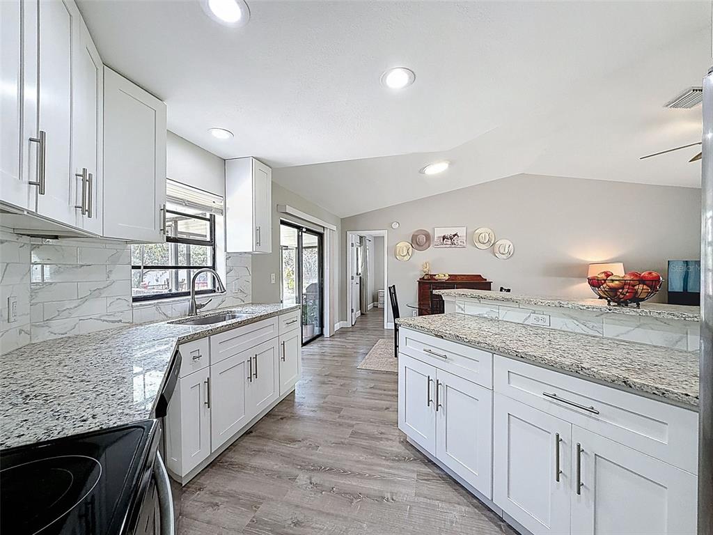 5384 Baldock Avenue Spring Hill, FL 34608 - Photo 24 of 51 a kitchen with granite countertop white cabinets and white appliances