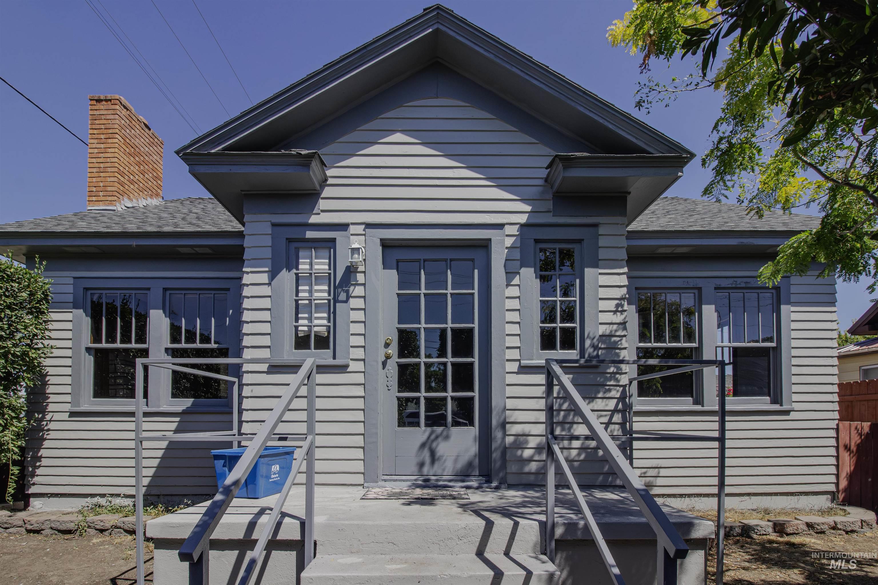 View of front of property with a shingled roof and a patio area