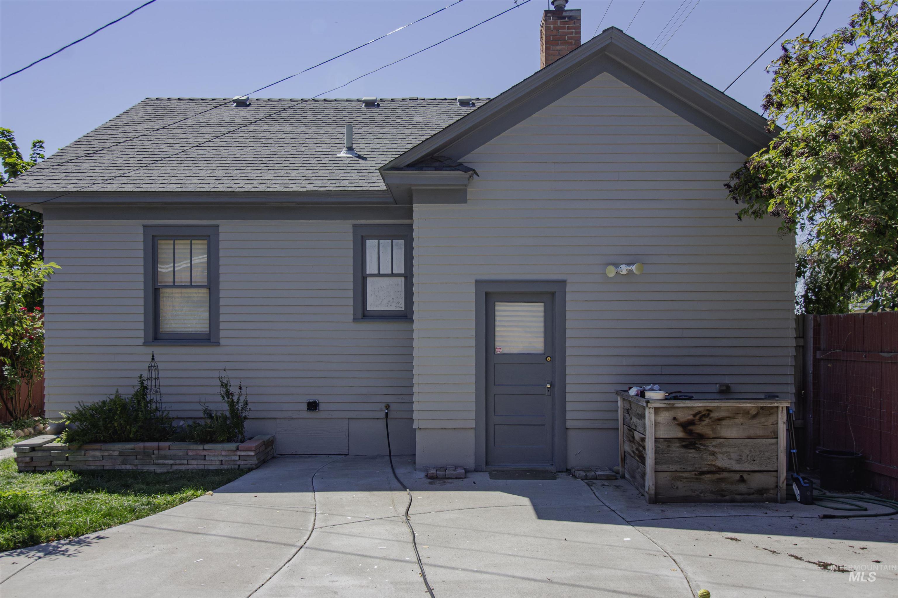161 Southeast 5th Avenue Ontario, OR 97914 - Photo 36 of 41 Back of house featuring roof with shingles and a chimney