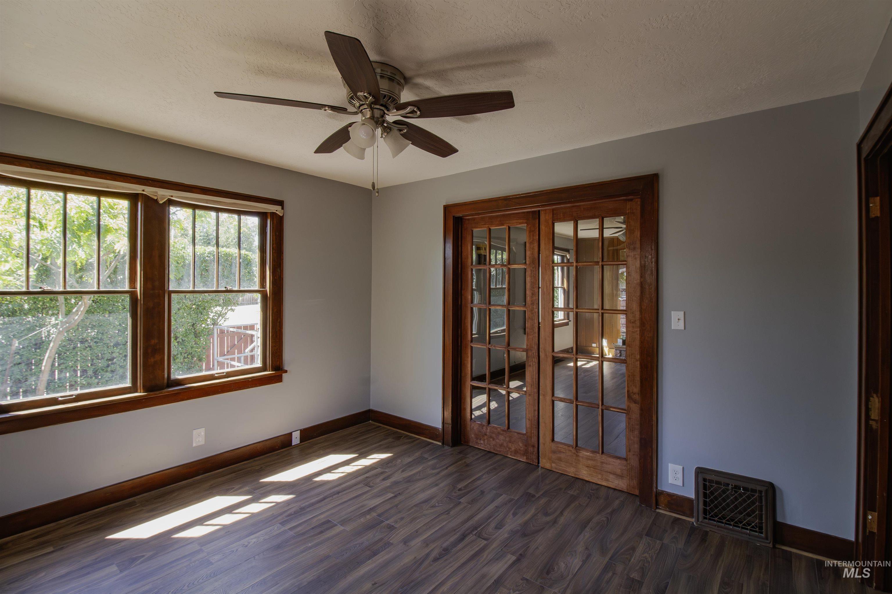 161 Southeast 5th Avenue Ontario, OR 97914 - Photo 39 of 41 Unfurnished room featuring ceiling fan, dark wood-type flooring, a textured ceiling, and french doors