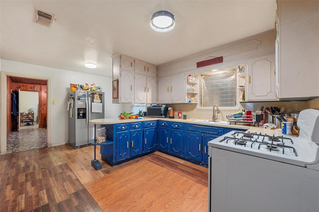 812 Hubert Street Waco, TX 76704 - Photo 14 of 22 a kitchen with stainless steel appliances granite countertop a stove a sink dishwasher and a refrigerator with wooden floor