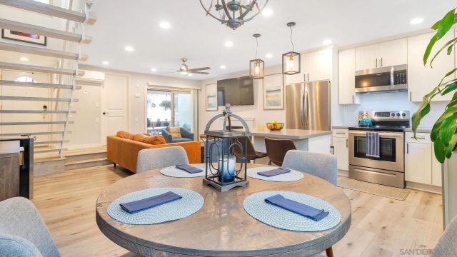 a dining room with furniture a chandelier and wooden floor