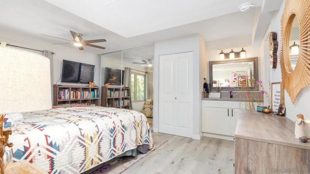 a bedroom with a large bed and a large mirror on dresser