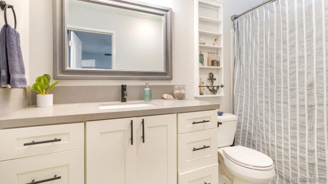 a bathroom with a granite countertop sink toilet and a mirror