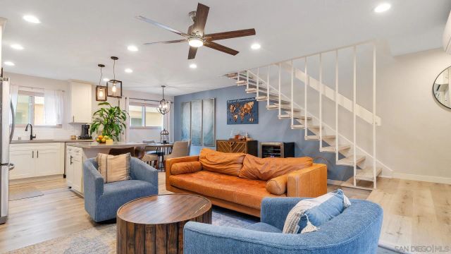 a living room with furniture a ceiling fan and a window