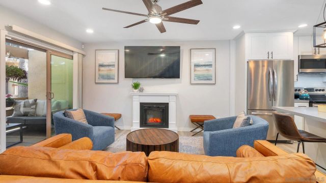 a living room with furniture fireplace and a large window