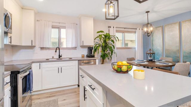 a kitchen with stainless steel appliances granite countertop a sink refrigerator and microwave