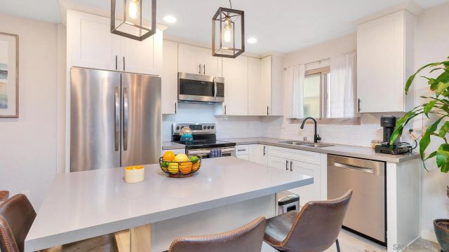 a living room with furniture kitchen view and a wooden floor