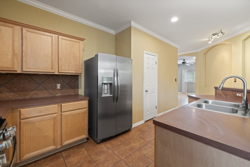 347 Spring Drive Kyle, TX 78640 - Photo 12 of 40 A well-appointed kitchen showcasing durable tile flooring and natural wood cabinetry.